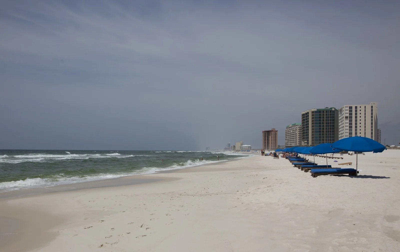 White sand Gulf shoreline with beach umbrellas and condominium towers at Orange Beach, Alabama