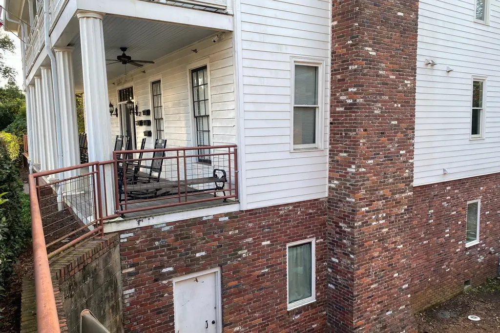 Inspection of a brick foundation entry point during a Birmingham, AL rodent exclusion job
